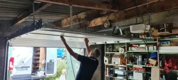 Pose intérieure d’une porte de garage motorisée avec rails et mécanisme à Saint-Bernard.