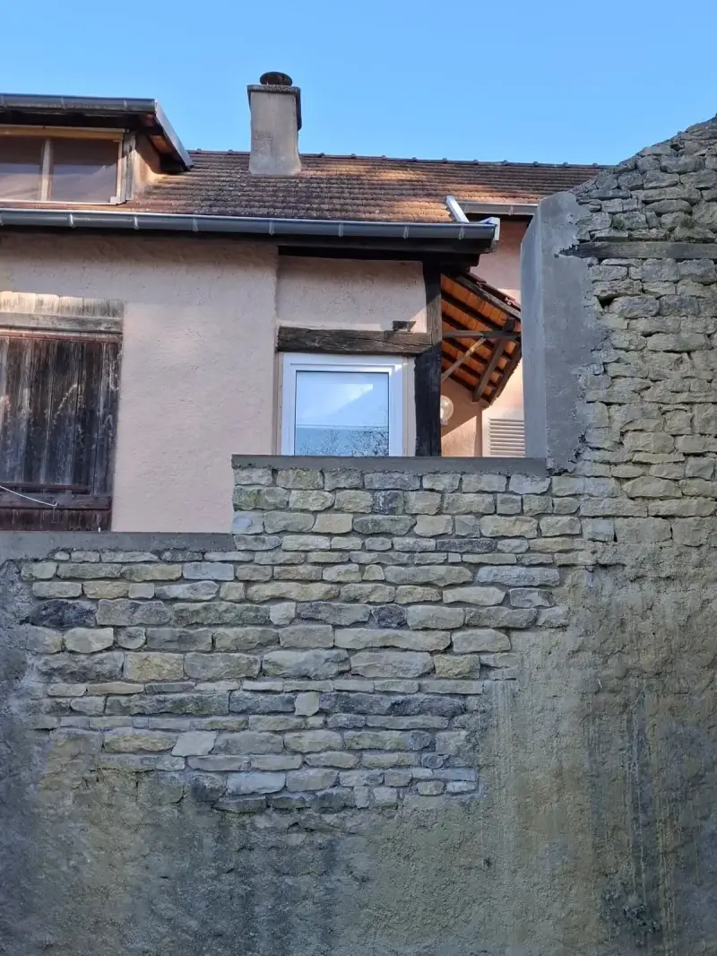 Mur en pierre restauré à Ségrois avec finition traditionnelle et pierres apparentes.