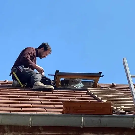 Couvreur-zingueur en intervention sur une toiture pour la pose d’une fenêtre de toit près de Nuits-Saint-Georges