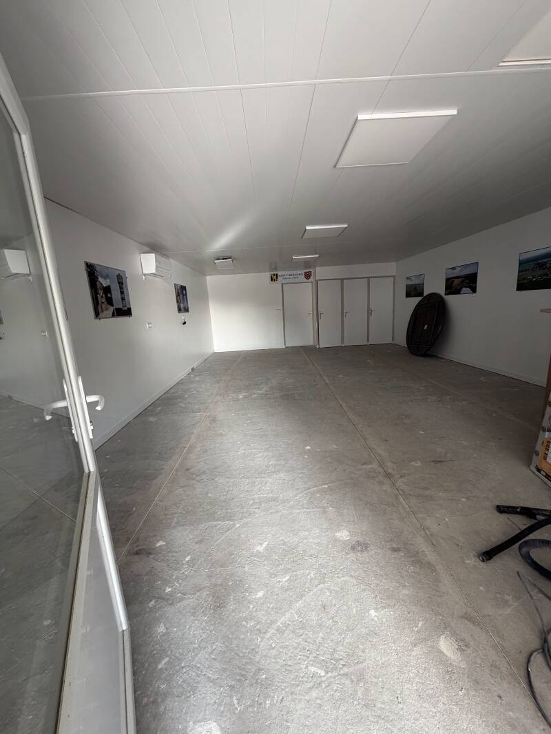 Chantier de rénovation de sol intérieur dans une salle communale.