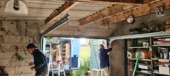 Installation des rails d’une porte de garage sectionnelle à Saint-Bernard lors d’un chantier de rénovation.