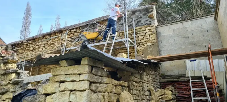 Application d’un enduit à la chaux sur un mur en pierre rénové à Ségrois.