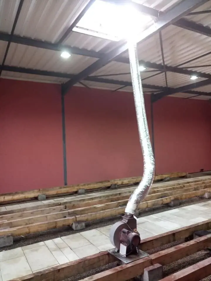 Espace de travail rénové dans une cuverie à Meursault avec tonneaux, réseaux techniques et ventilation.