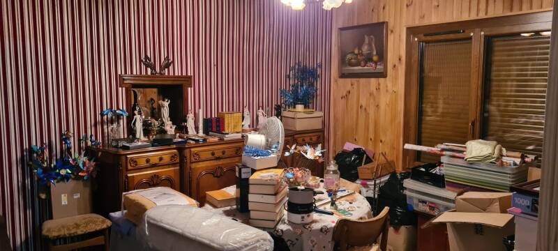 Avant travaux à Saint-Bernard : pièce de vie à rénover avec papier peint à rayures, lambris bois et aménagement ancien.