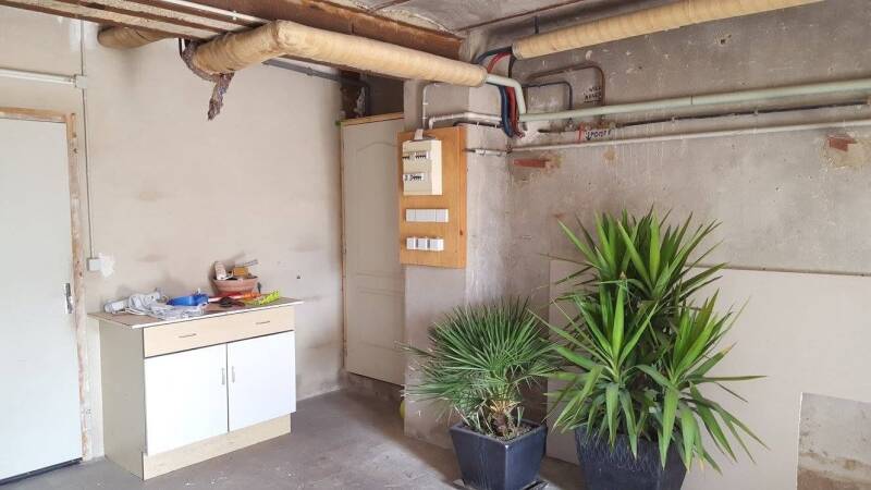 Avant travaux à Corgoloin : espace intérieur à rénover avec murs bruts, réseaux apparents et zone technique.