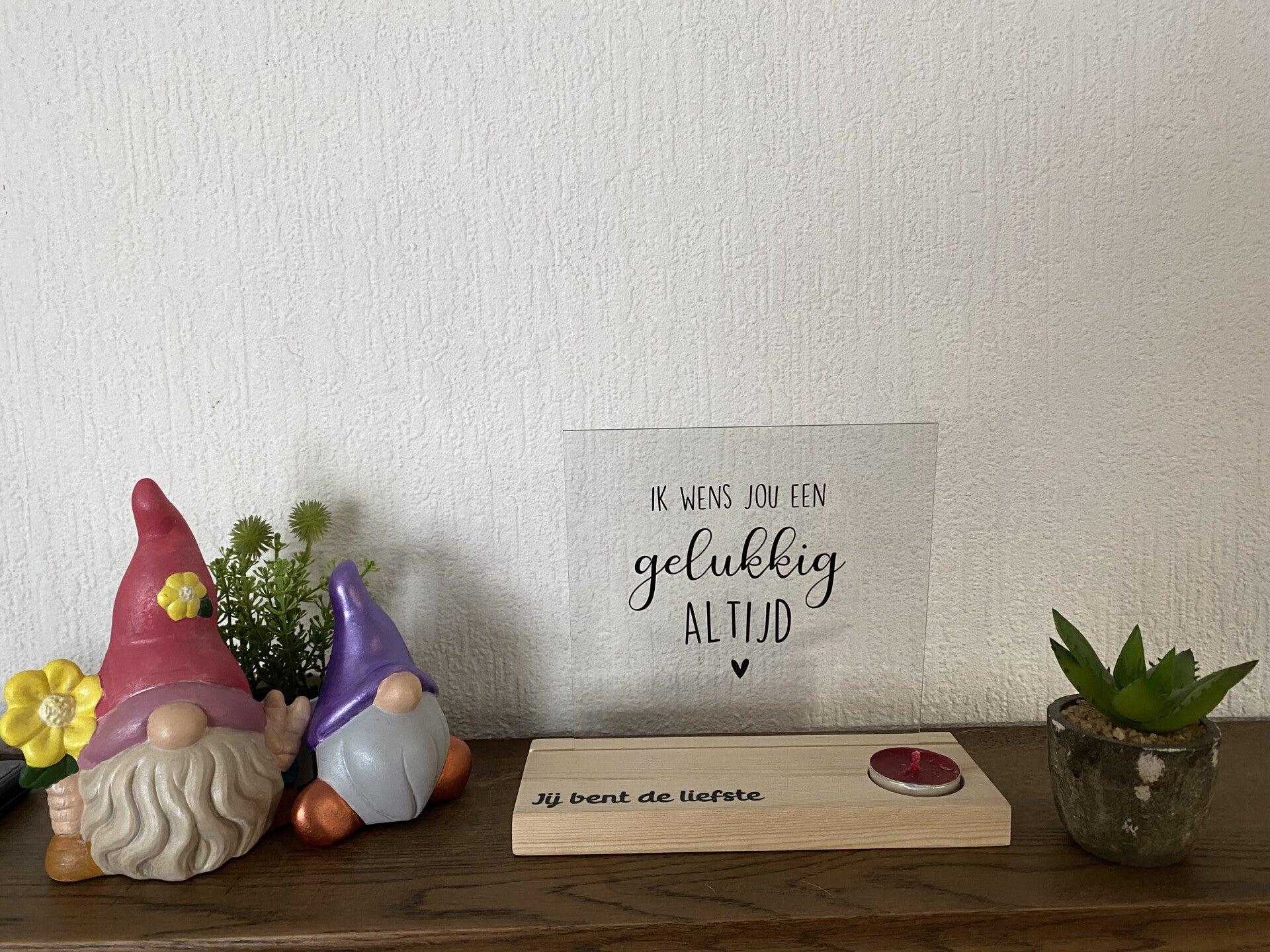 Houten plankje met waxinelichtje en glaasje met tekst