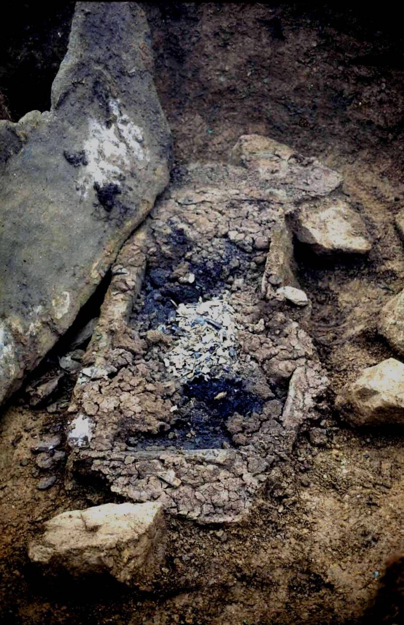La ciste ouverte : dipots de charbons do bois et d'ossements calcinés.
