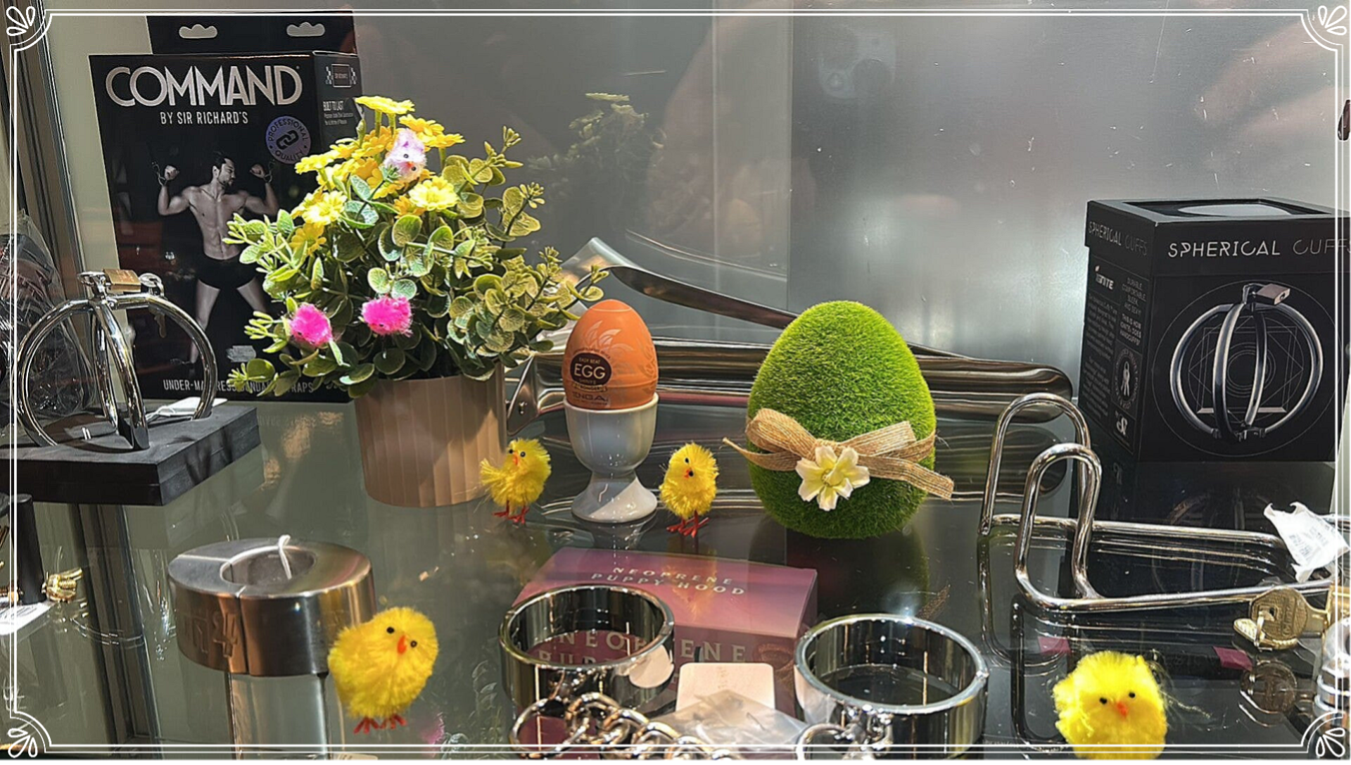 Vitrine Argos Love Shop Bruxelles Pâques 2026 rue des Riches-Clairs, décorations œufs Pâques poussins jaunes fleurs jaunes produits Commandant, Spherical Luxe, menottes, boules de geisha, boutique bien-être sexuel intime Bruxelles 1000
