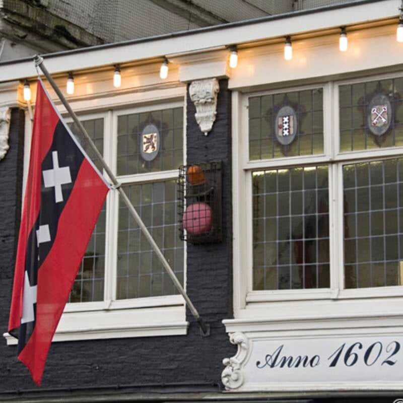 Detailed view of an Amsterdam flag displaying three red crosses, a symbol of the city’s heritage.