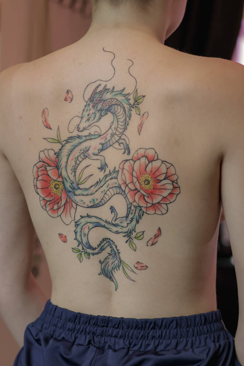 Farbiges Neo-Traditional Rücken-Tattoo mit asiatischem Drachen und Blumen.
