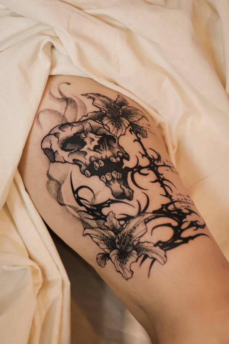 Oberschenkeltattoo totenkopf Tribal blackwork mit Fineline gemischt