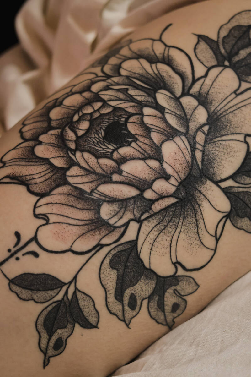 Abgeiltes florale Blume in blackwork auf dem Oberschenkel