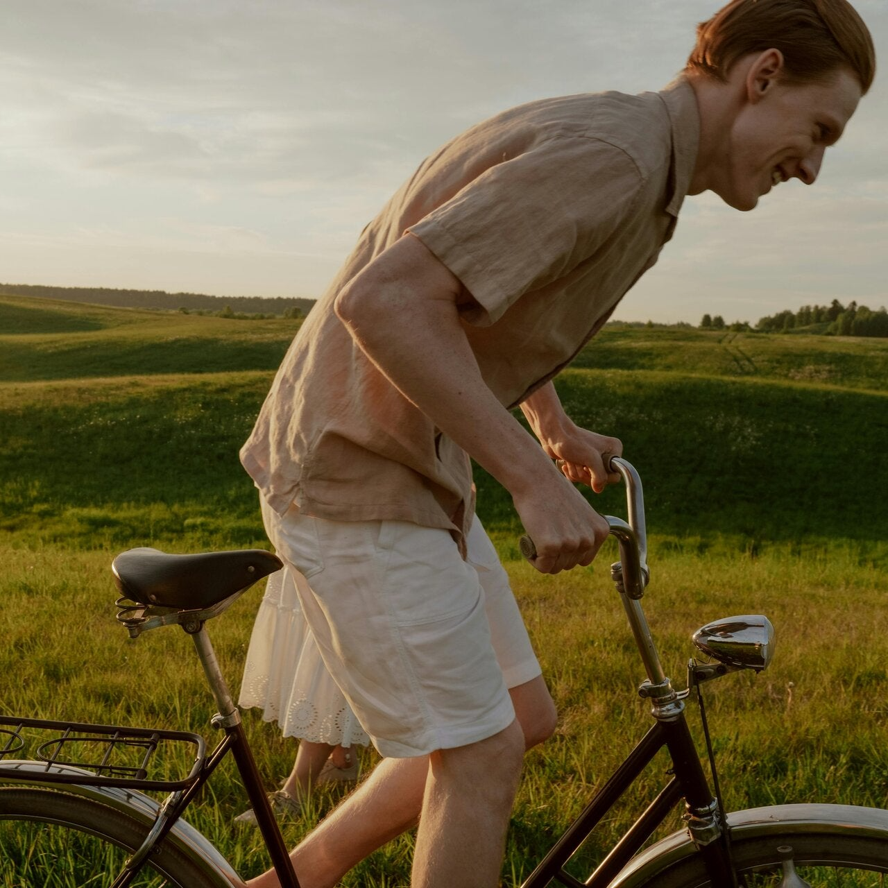 Man, in de natuur, die staande fietst.