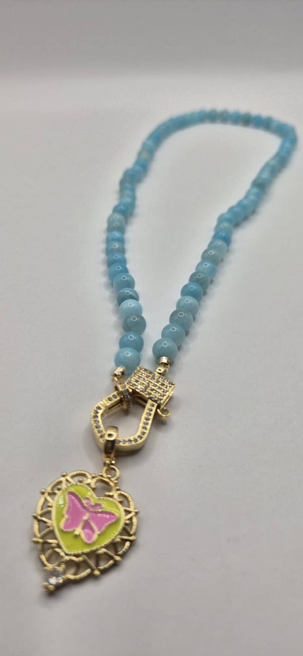 Korte hemelsblauwe kralen ketting met limegroene bedel met vlinder