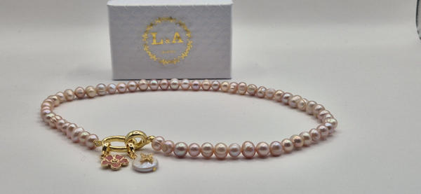 Roze parelketting met 2 bedels: roze bloem & parel