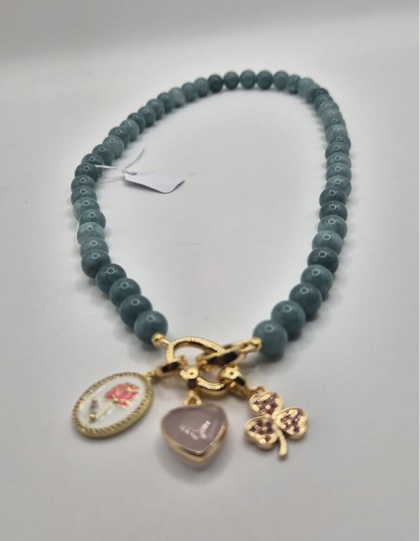 Blauwgroene kralen ketting met 3 bedels: roze bloem, roze hart & roze klaver