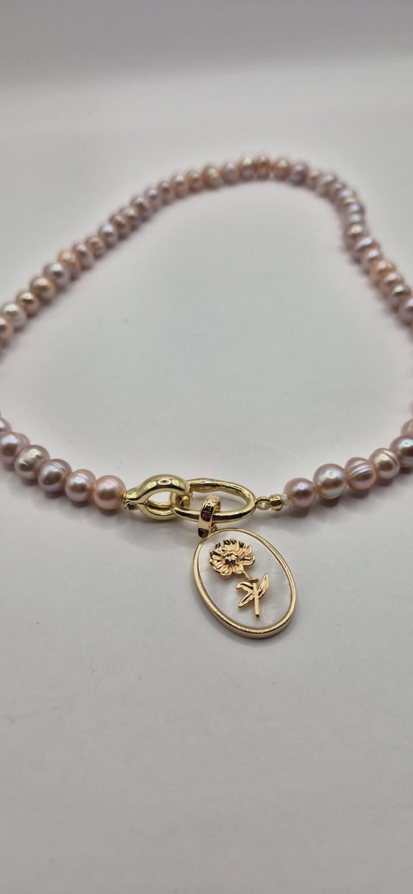 Roze parelketting met 1 bedel: ovale parelmoer met zonnebloem