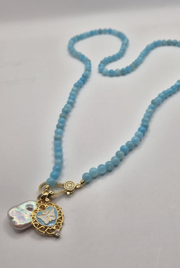 Licht blauwe parel lange ketting met 2 bedels: grote parel & vlinderbedel