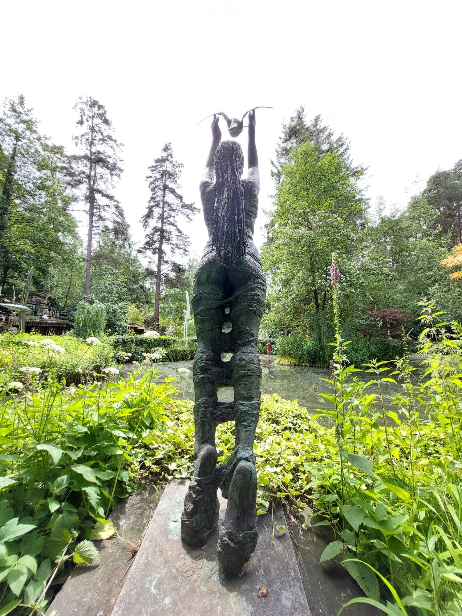 Sculpture reaching upwards in a woodland garden