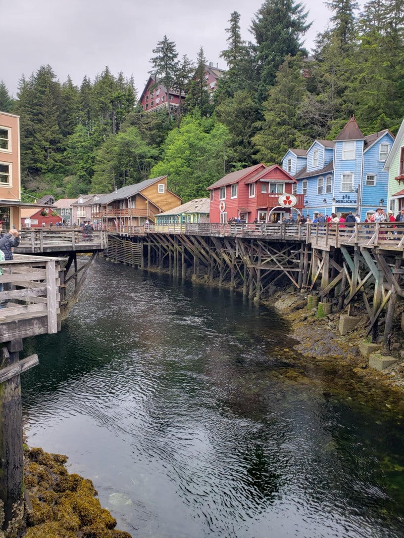 Historic Creek Street boardwalk in Ketchikan, Alaska with wooden buildings on stilts above the salmon stream