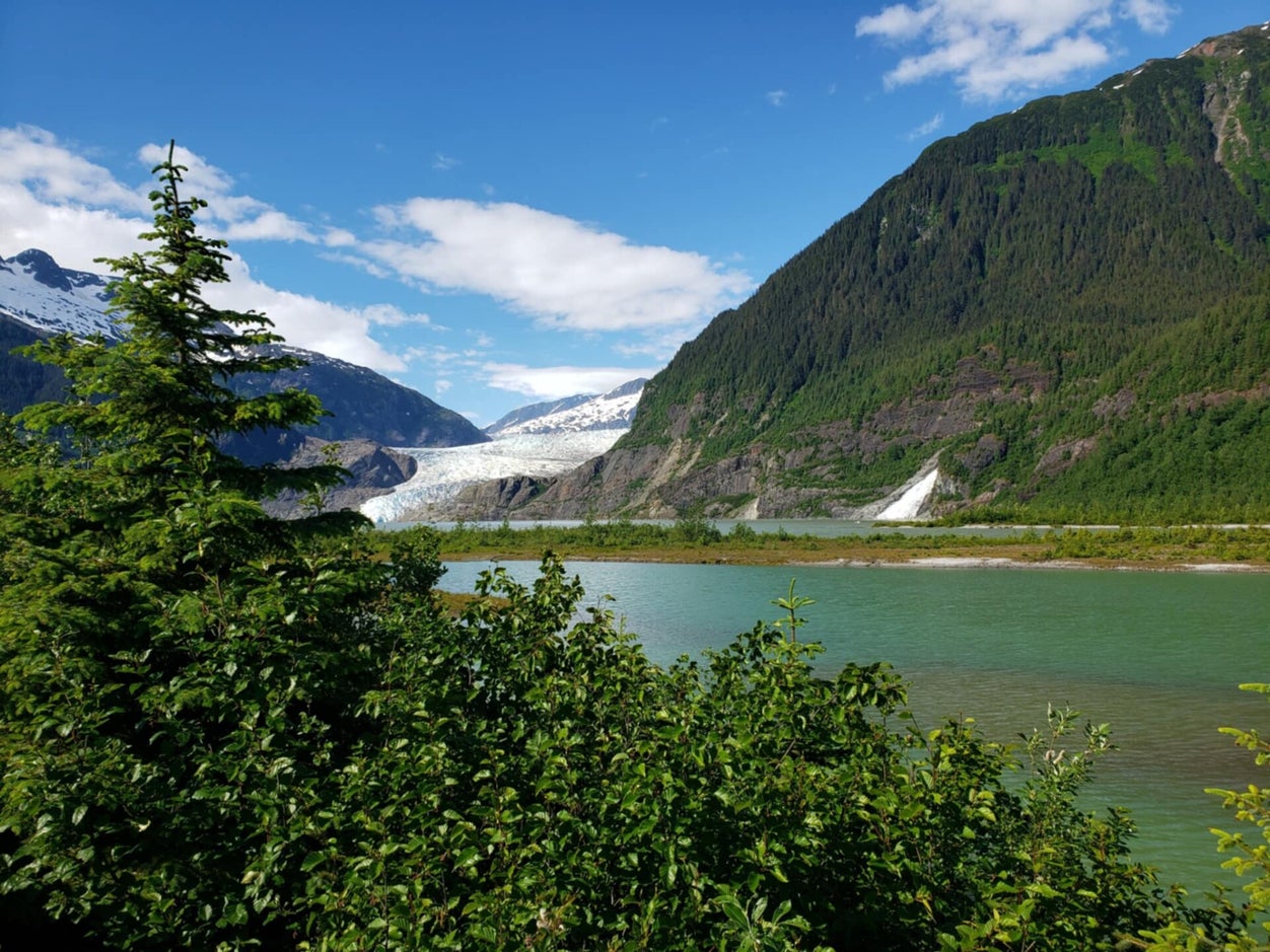Mendenhall Glacier near Juneau, Alaska with icebergs in the foreground and forested mountains rising behind