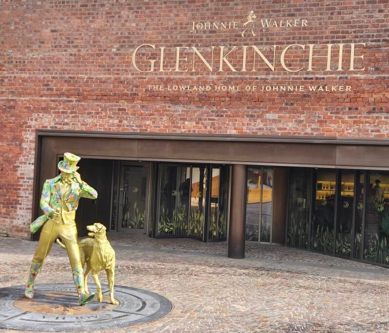 Entrance to Glenkinchie Distillery near Edinburgh, the Lowland home of Johnnie Walker, with the colourful Striding Man statue outside the visitor centre.