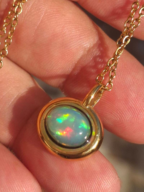 Pendentif acier inoxydable plaqué or avec opale multicolore reflet. Pierre de 9x7mm véritable