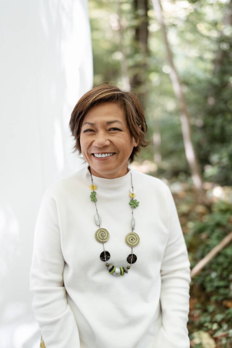 Nhung-Hélène, accompagnante holistique et Human Design, portrait souriant en col roulé blanc, page contact, Sentiers Lumineux Vers Soi