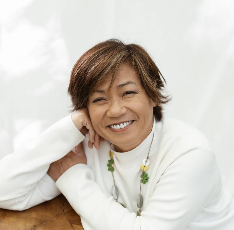 Nhung-Hélène, accompagnante holistique et Human Design, portrait souriant en veste blanche, page réservation appel Clarté, Sentiers Lumineux Vers Soi