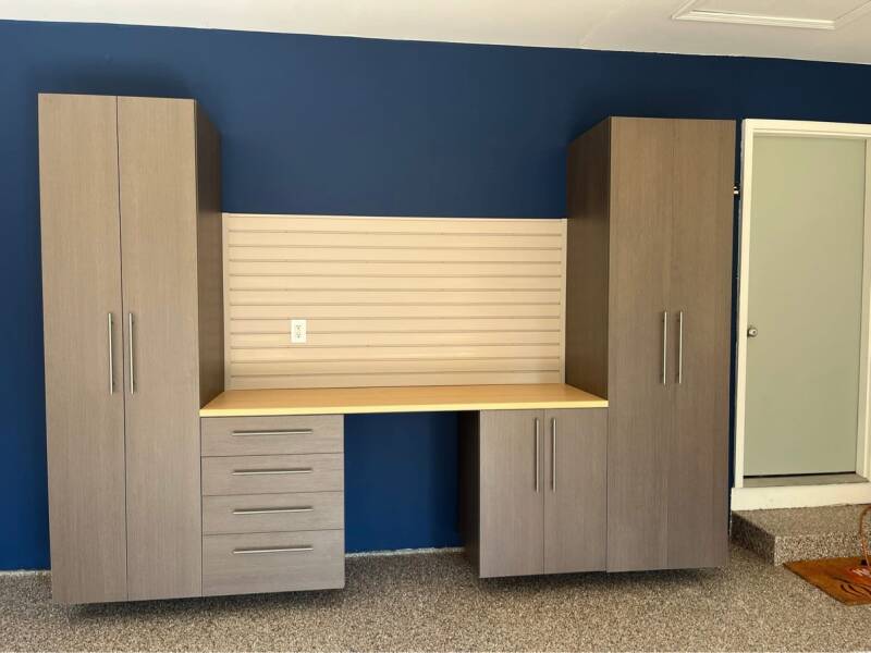 Deluxe package: gray workstation with two tall cabinets flanking a work counter with drawers, door cabinet, and slatwall