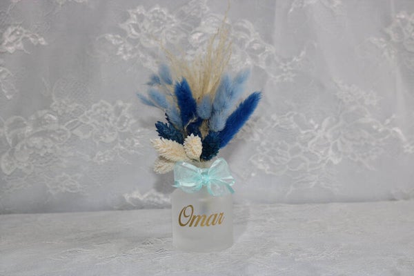 Frosted vaasje gevuld met droogbloemen