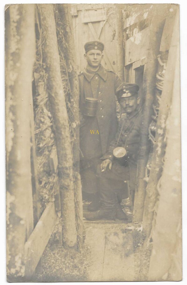 German Photo card from 1917 of 2 soldiers in a trench with gas mask canisters.