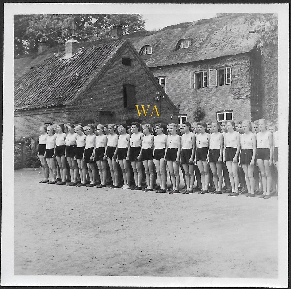 A large group of BDM girls lined up for roll call in sportswear.