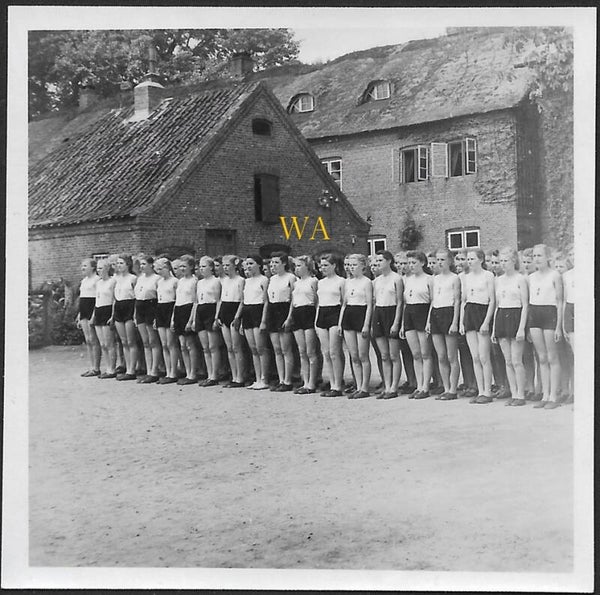 A large group of BDM girls lined up for roll call in sportswear.