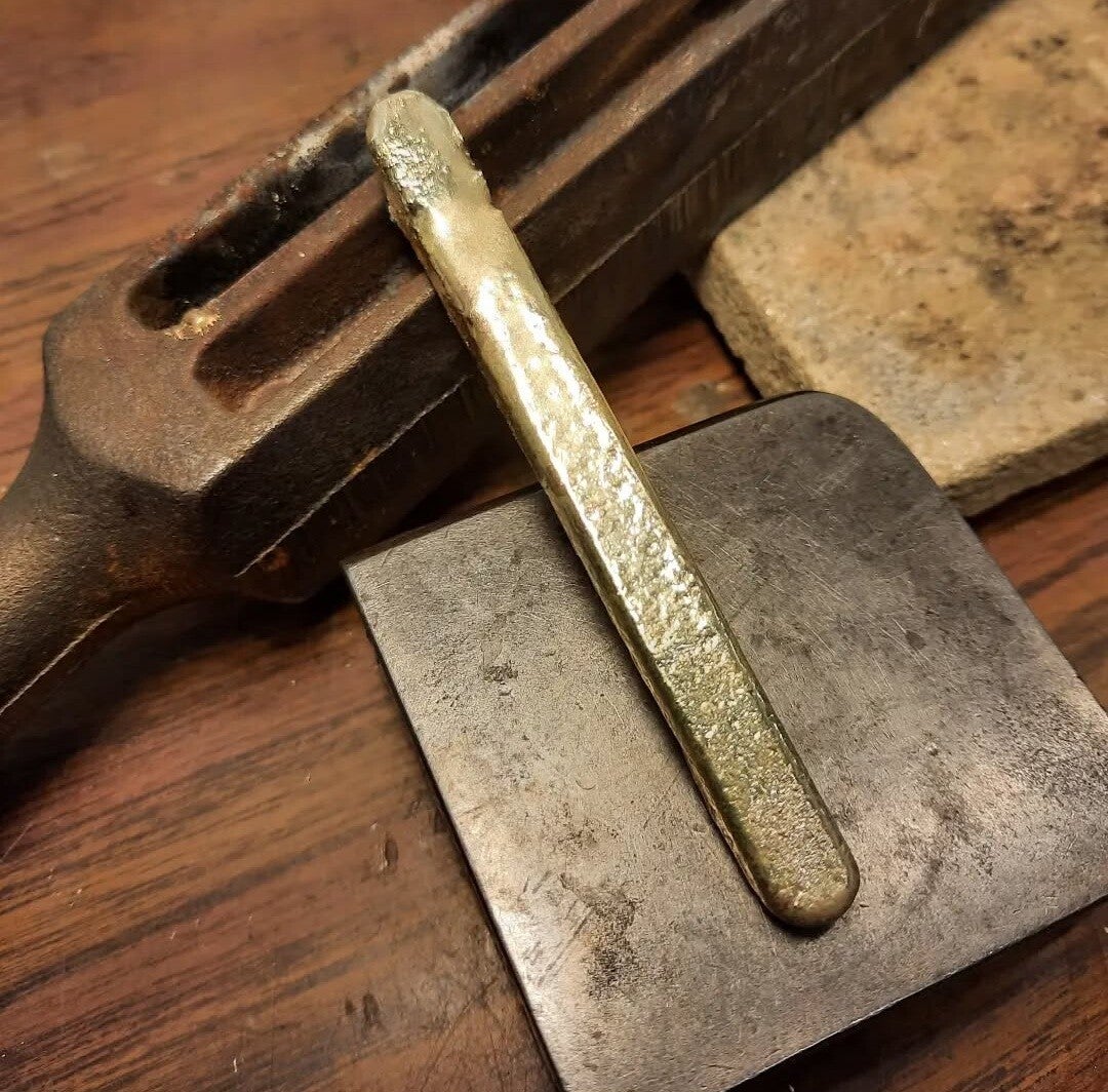 Ruwe goudbaar na het omsmelten van oude sieraden, klaar om gesmeed te worden tot een uniek ontwerp.