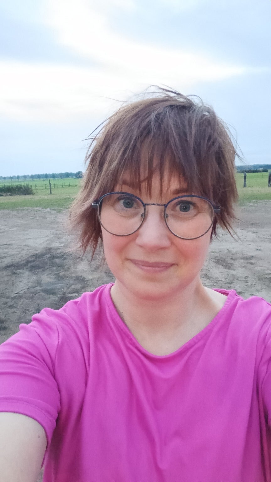 Judith Peinemann naast een paard bij de stal