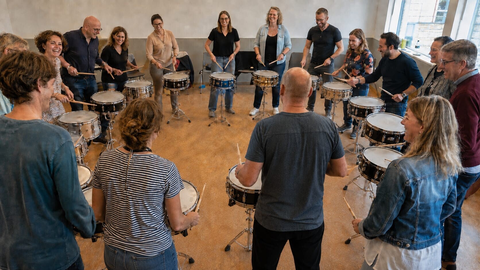 Een team speelt samen op trommels in een kring tijdens een workshop