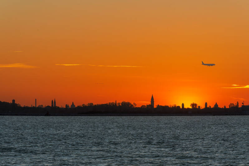 2024-04-02 Tramonto su Venezia da Punta Sabbioni con aereo che sta atterrando