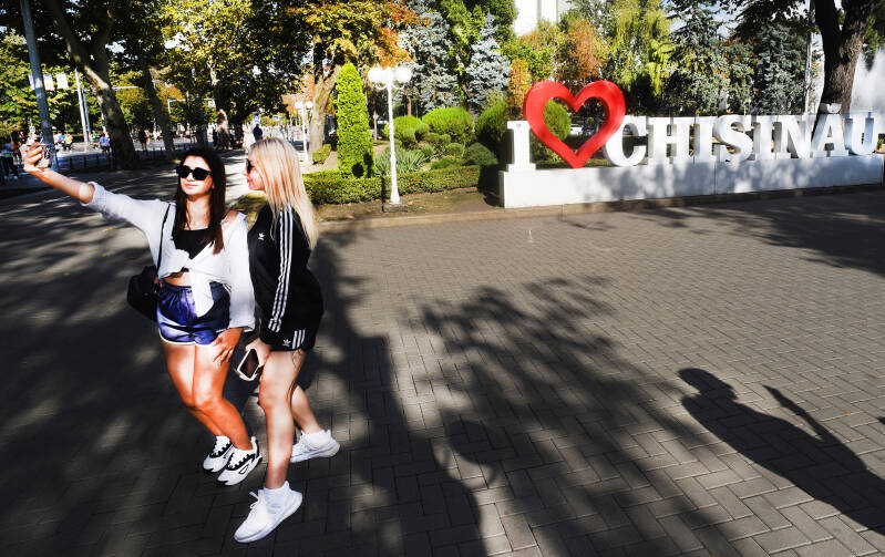 young women on street of Moldova posing for a selfie, documentary photographer Bob Brunschot publishes with the centre for british documentary photography, for humanity photo magazine,