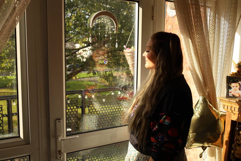 female magic mushroom user and guide, looks out her window while explaining the healing properties,