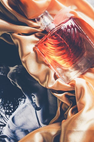 Lancome La Vie Est Belle Iris Absolu perfume bottle on golden silk and artistic background