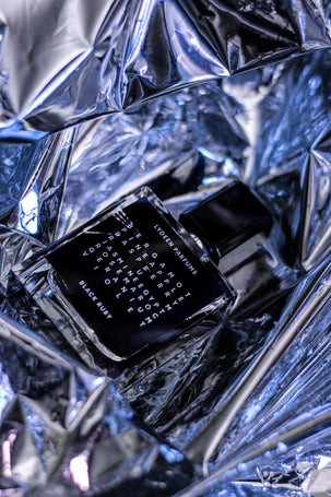 1. Black perfume bottle with white text in a metallic setup