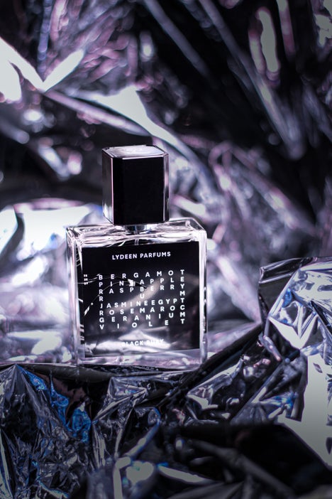 1. Artistic shot of a luxury fragrance bottle on reflective foil