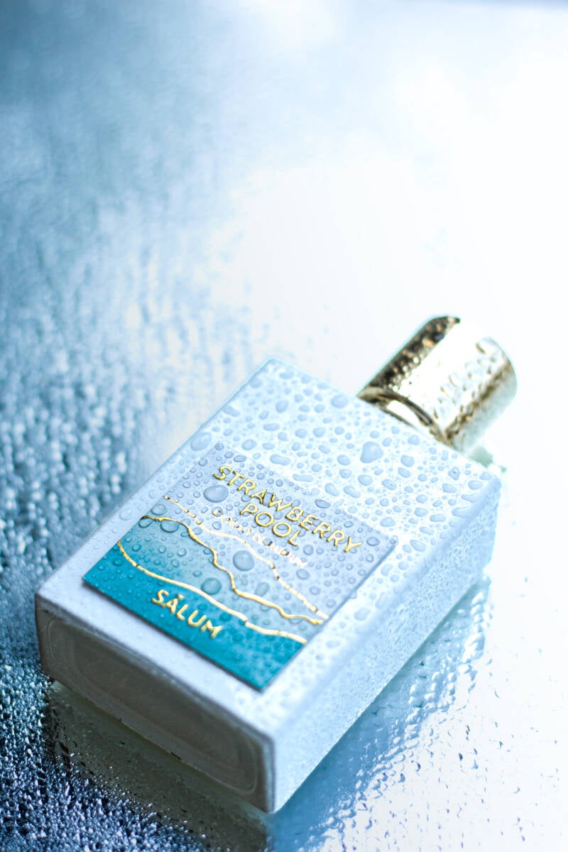 Strawberry Pool niche perfume bottle on wet glass surface
