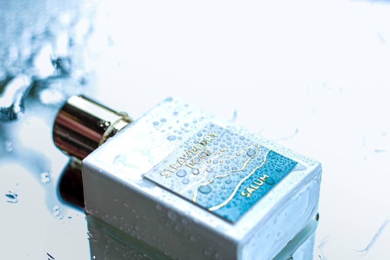 Top view of Strawberry Pool bottle in a water-themed setting