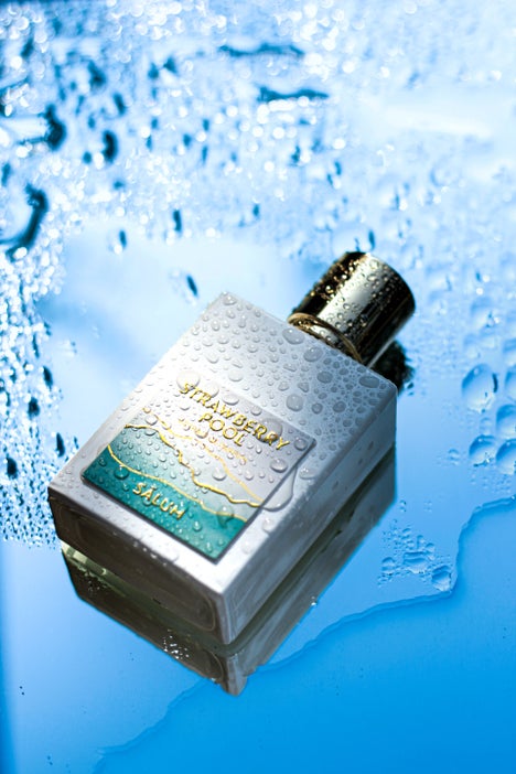 White bottle of Strawberry Pool by Salum lying on a blue wet surface