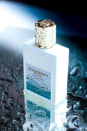 Extrait de Parfum Strawberry Pool bottle on reflective water background