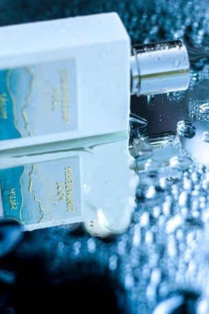 Close-up of Strawberry Pool by Salum bottle with water droplets