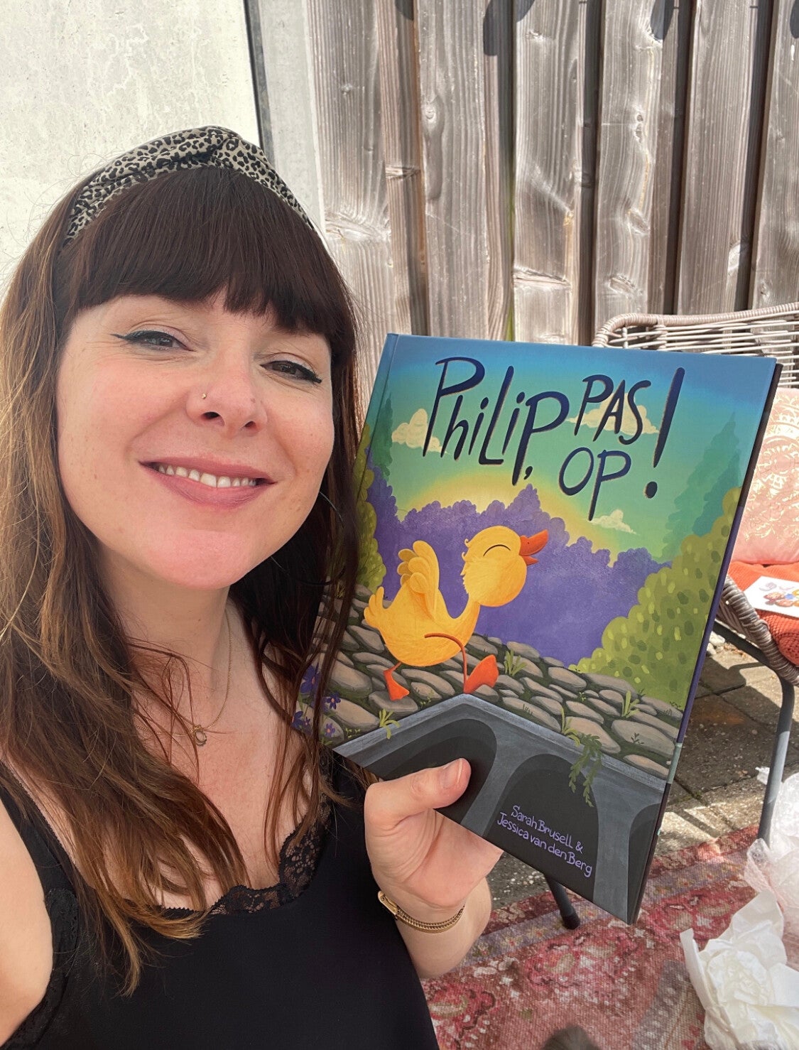 Foto van illustrator Jessica van den Berg, met het prentenboek Philip, pas op. Op he boek staat een geel eendje.