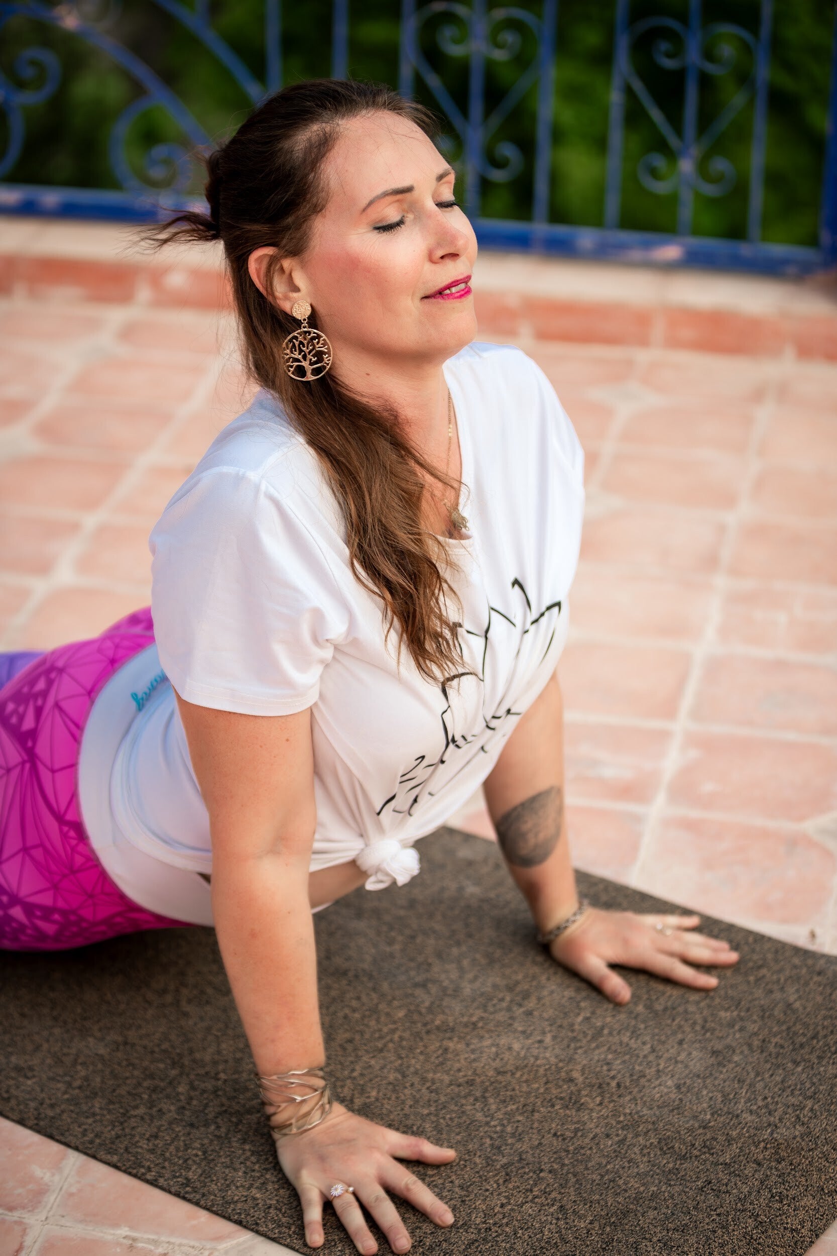 Yoga teacher practising Downward-Facing Dog at a traditional riad during a Marrakech yoga retreat in Morocco.